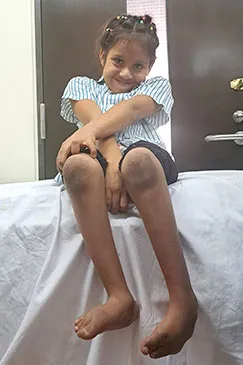 A child seated on an examination bed