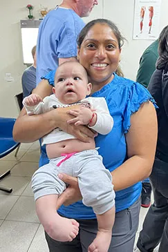 A baby held in a caregiver's arms